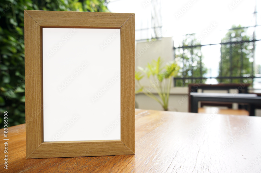 Mock up Blank white frame standing on wood table in Bar restaurant cafe. space for text. product display montage. Mock up Blank white frame standing on wood table in Bar restaurant cafe. space for text. product display montage.