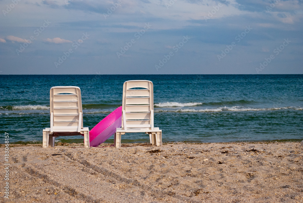 two white chaise longue and pink inflatable circle on the beach on the blue sea shore water blue sky sea wave beautiful landscape summer vacation beach sand weekend rest