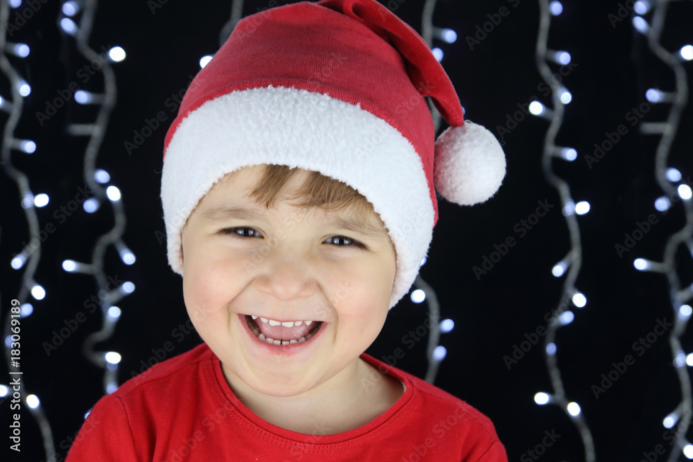 niño feliz riendo con disfraz de santa claus en un fondo negro con ...
