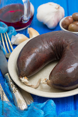 smoked blood sausage on white dish on wooden background photo