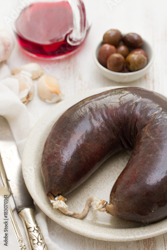 smoked blood sausage on white dish on wooden background