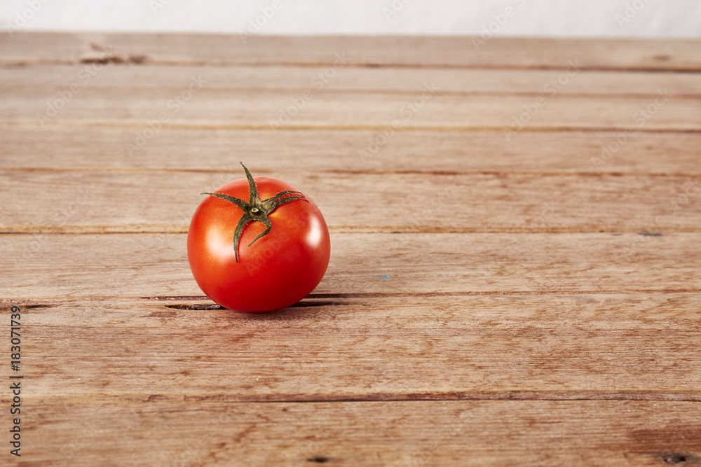 One ripe tomato on a decorative board. One ripe tomato on a decorative board.