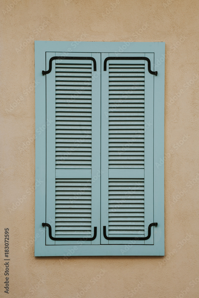 Wooden window shutters isolated on yellow wall urban background.