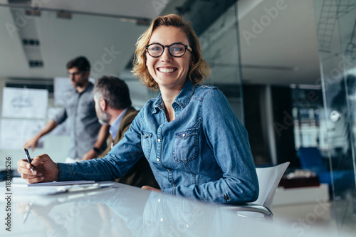 Female office worker  sitting in board room photo