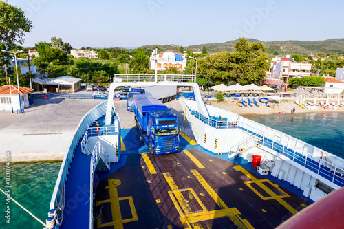 Lorry trucks are entering ferryboat, boarding cars