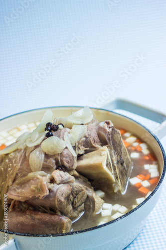 Kalbshachse mit Suppengemüse gekocht in einem Kochtopf photo