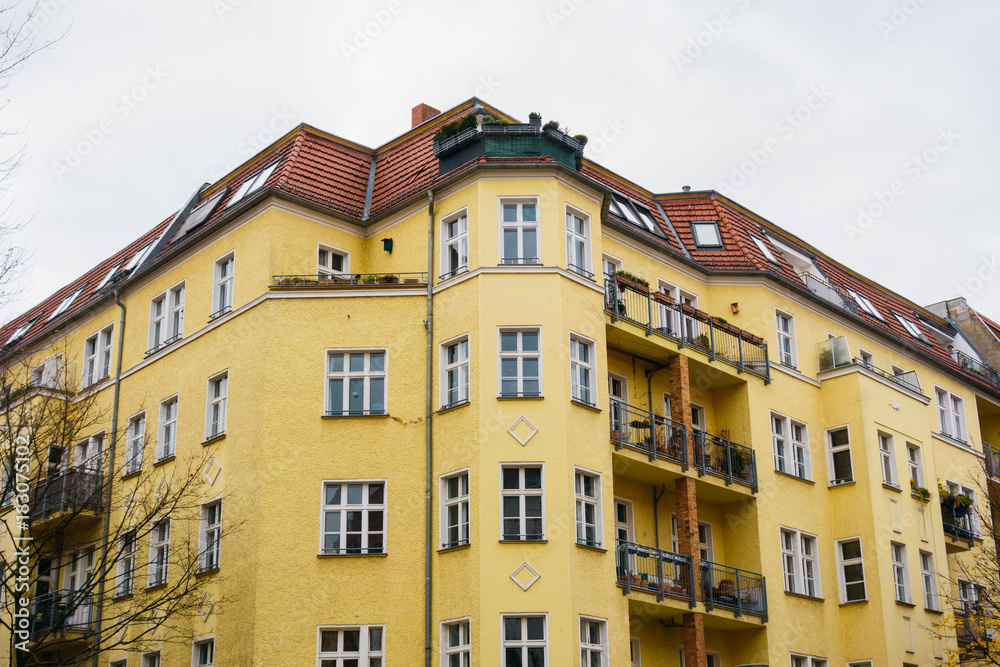 yellow big apartment building in berlin on a cloudy background