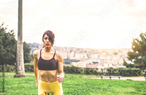 Young sportive woman running in the nature in a park outdoor - Sportswoman jogging in the city - Concept of healthy, lifestyle and sport