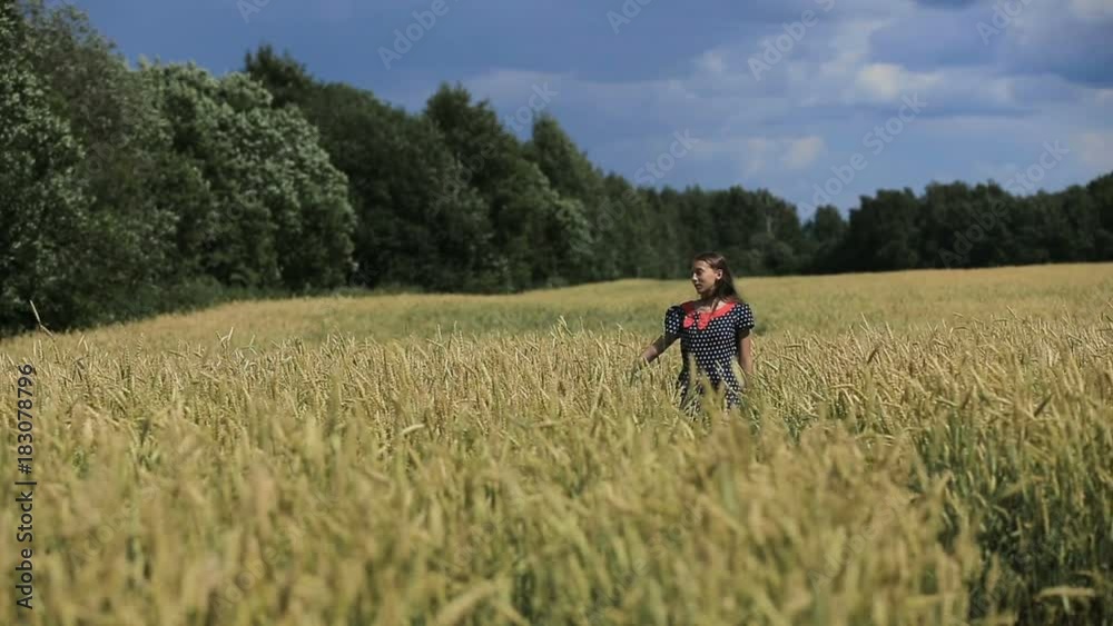 Hand in wheat field.Pretty young girl in black dress walking in a wheat field.Teen Girl in the countryside a wheat field. Hand in wheat field.Pretty young girl in black dress walking in a wheat field.Teen Girl in the countryside a wheat field.