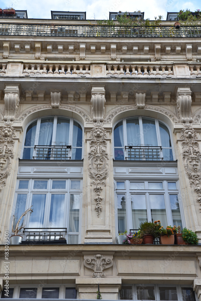 Grandes baies vitrées sur immeuble haussmannien à Paris, France