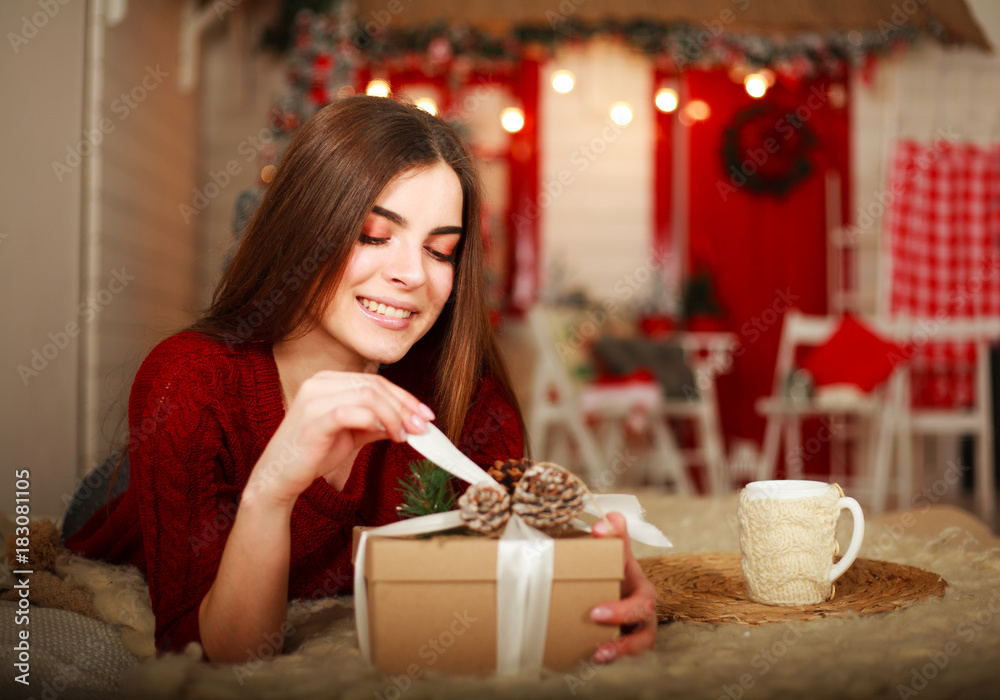 Woman open box with gift on background of Christmas decorations Woman open box with gift on background of Christmas decorations