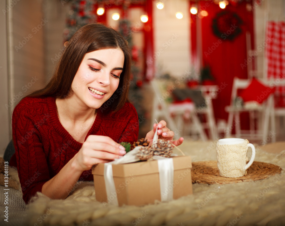 Woman open box with gift on background of Christmas decorations Woman open box with gift on background of Christmas decorations