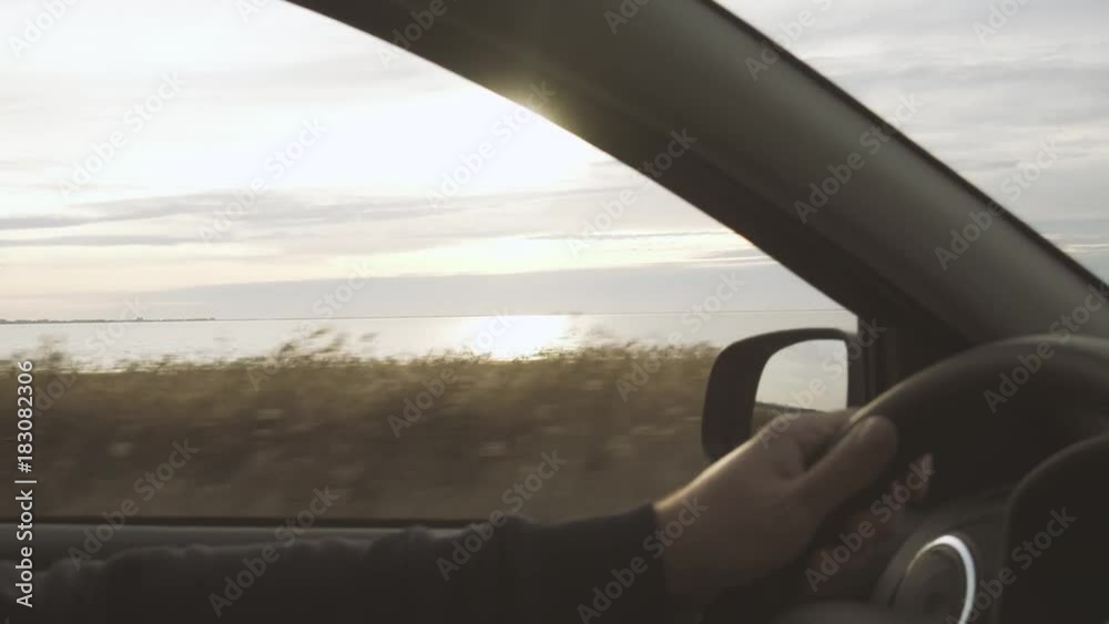 Hands of the driver on the steering wheel outside the car landscape Hands of the driver on the steering wheel outside the car landscape