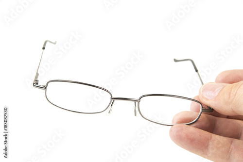 Eye glasses metal frame in the hand on white background