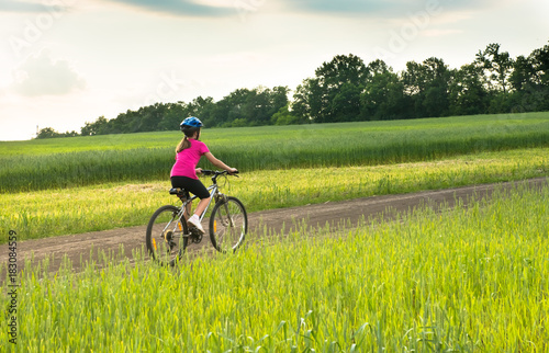 girl on a bicycle in rural landscape