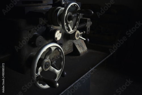 close up vintage old vault of turning equipment industrial lathe machine and vernier in low key lighting