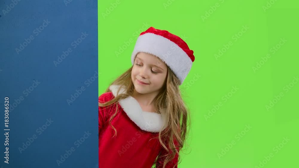 Child girl peeking out from behind the blue board. Green screen. Slow motion Child girl peeking out from behind the blue board. Green screen. Slow motion