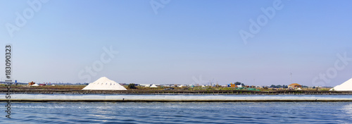 Aveiro / Portugal August 13, 2017: Main canal with views of the heaps of salt, the main and typical production of the town and the bridge over the highway. In the background the town