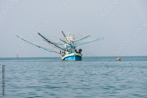 Fishing or squid hunter boat in blue sea on solf sky .