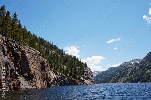 Forest with cliffs by mountain lake