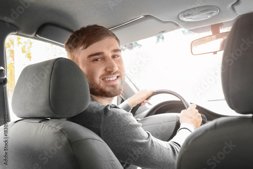 Handsome young man driving ...