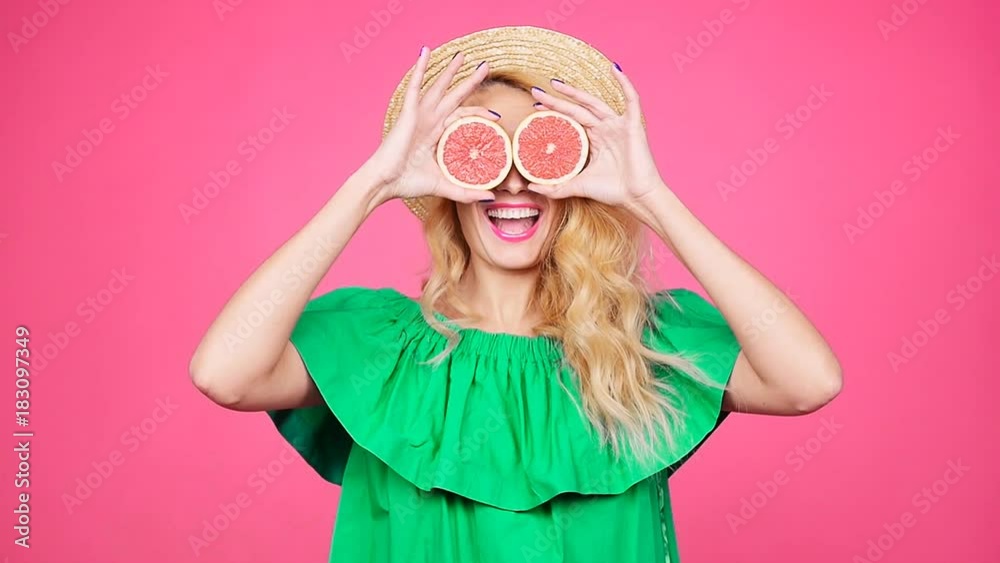 Happy young woman with two half of juicy grapefruit instead eyes Happy young woman with two half of juicy grapefruit instead eyes