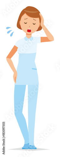 A woman nurse wearing a white uniform is tired
