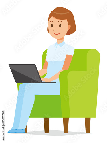A woman nurse wearing a white uniform is sitting on the sofa and operating a laptop computer