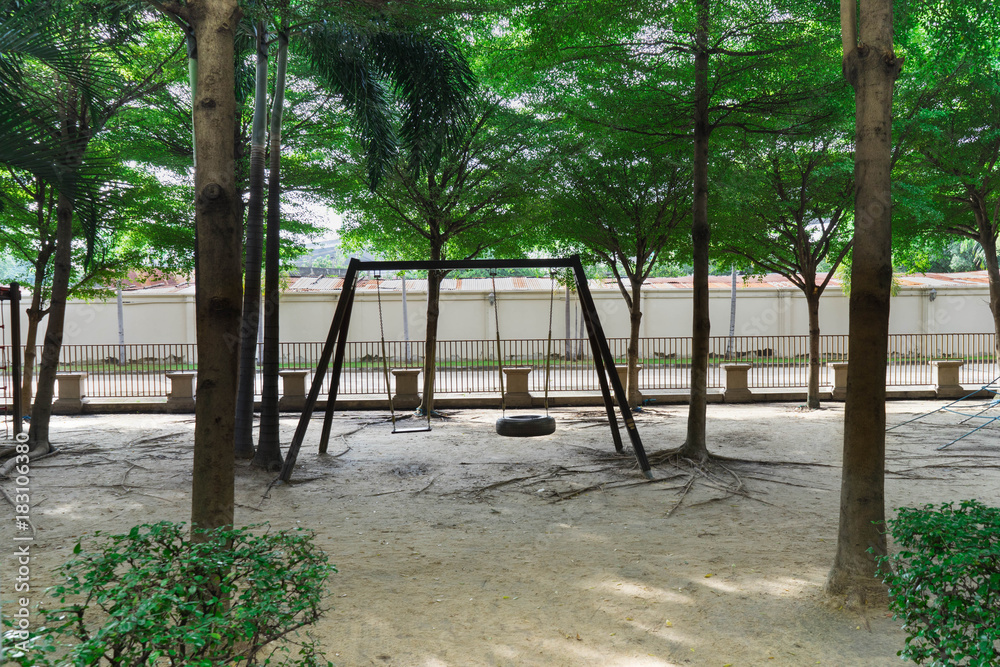 swing in playground under pleasant of trees feel happy and shady concept