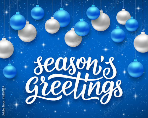 Seasons greetings script text on blue background with sparkles and colorful hanging balls. Vector illustration for holidays with lettering