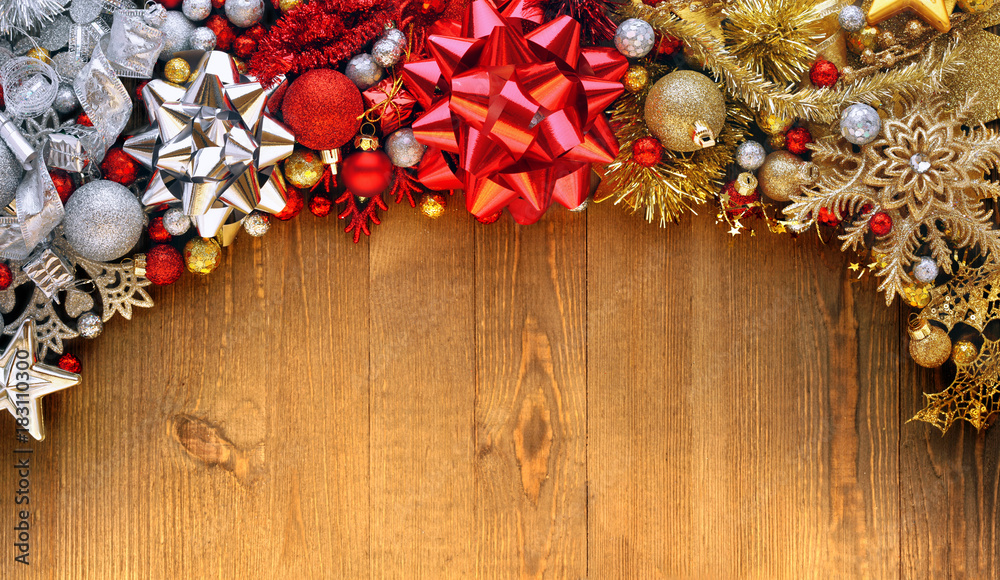 Christmas bows, ornaments, and decorations on wooden background