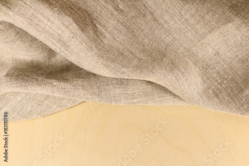 Linen unpainted fabric with folds on the background of wood