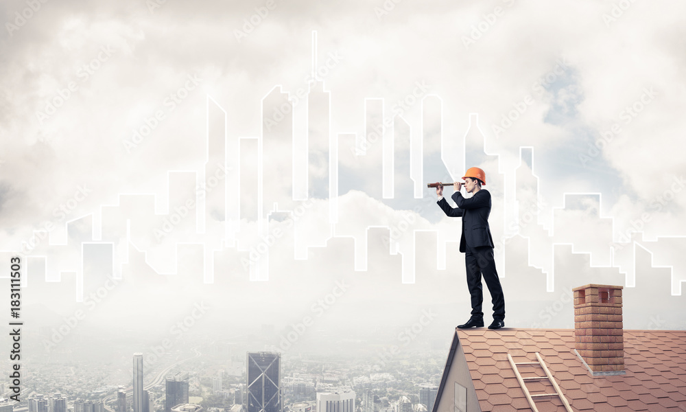 Engineer man standing on roof and looking in spyglass. Mixed med Engineer man standing on roof and looking in spyglass. Mixed med