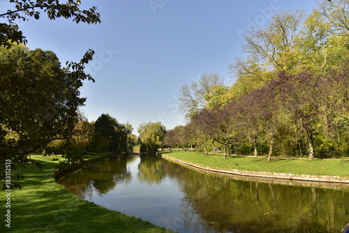 Courbe du chenal principal et son effet miroir reliant le petit et le grand étang dans un cadre verdoyant au Vrijbroekpark à Malines