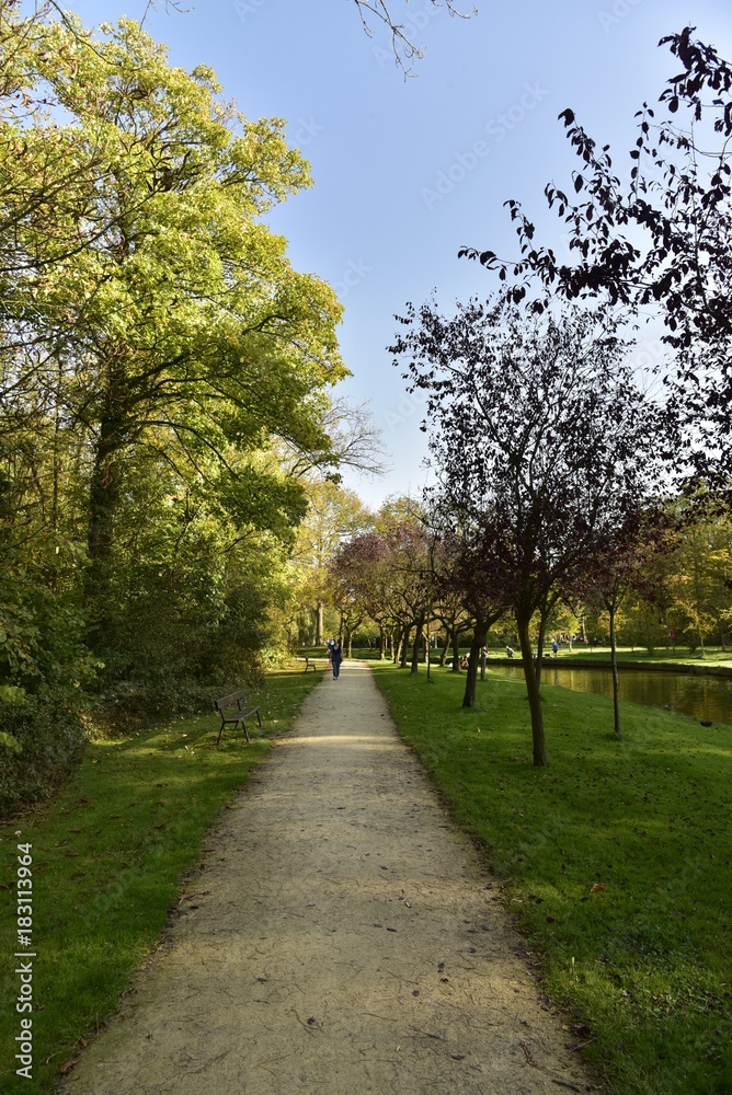Chemin en gravier beige longeant le chenal principal du Vrijbroekpark à Malines