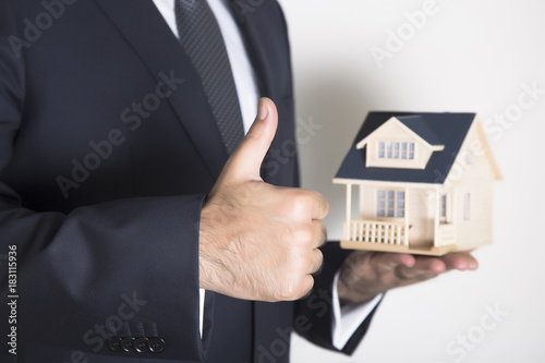 Hand of the businessman with the house 