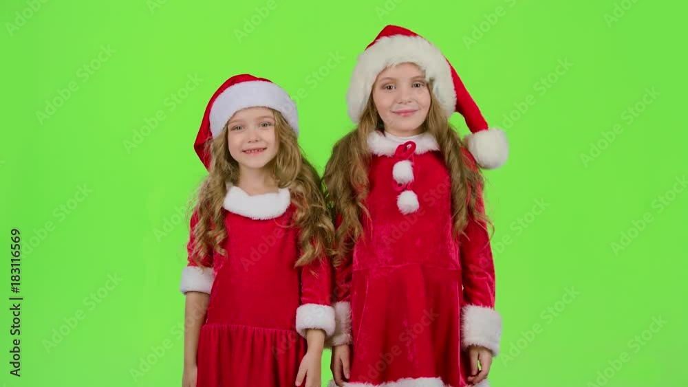 Children in red Christmas caps send air kisses. Green screen Children in red Christmas caps send air kisses. Green screen