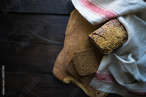 Homemade organic rye bread on cutting board with vintage towel