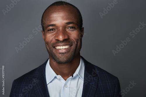 Happy glance. Portrait of delighted young attractive african man is looking at camera with joy. He is sharing positivity and optimism. Isolated background