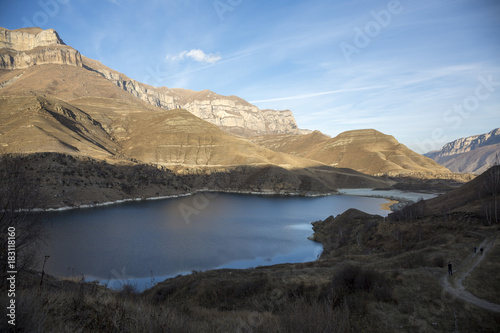Горное озеро в живописном ущелье, панорама с красивыми скалами, водоем с голубой водой, природа Северного Кавказа