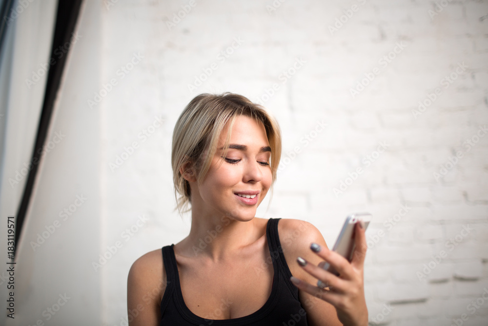 Smiling woman intelligent office worker reading text message on mobile phone during work break in enterprise. Female manager watching news on website via cell telephone. Hipster girl using cellphone Smiling woman intelligent office worker reading text message on mobile phone during work break in enterprise. Female manager watching news on website via cell telephone. Hipster girl using cellphone