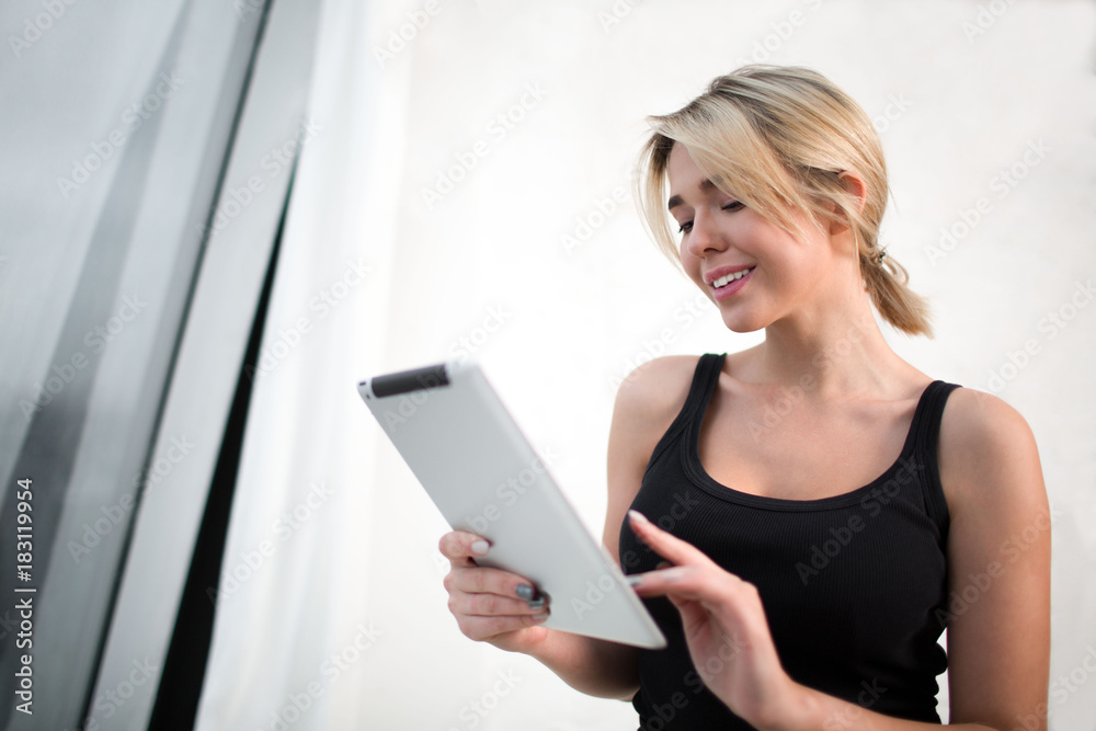 Smiling businesswoman checking e-mail on portable digital tablet, standing in office interior. Happy female manager having video call in internet via touch pad. Student using gadget for chat Smiling businesswoman checking e-mail on portable digital tablet, standing in office interior. Happy female manager having video call in internet via touch pad. Student using gadget for chat