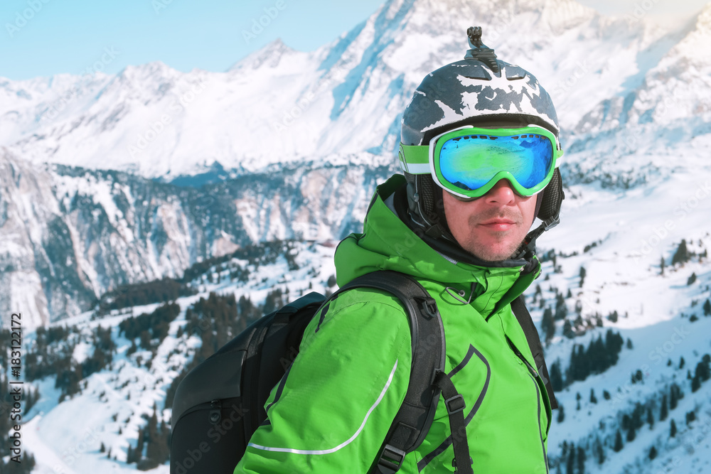 Skiing, portrait of happy male skier on top of mountain