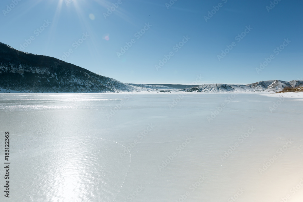 Frozen Lake with Mountains in the Background