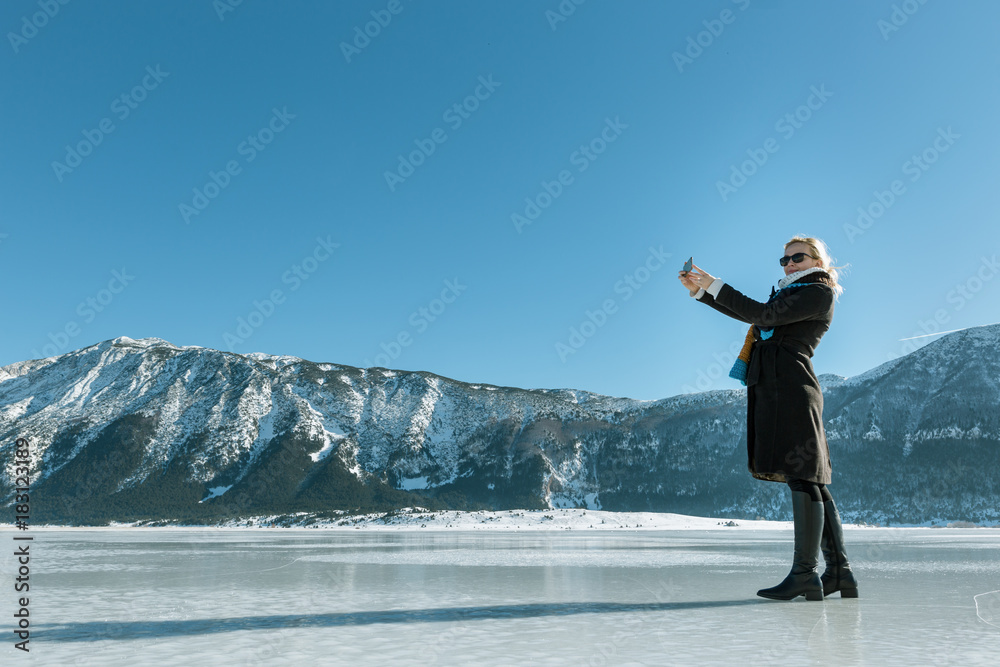 Pretty young female tourist takes selfie in winter Pretty young female tourist takes selfie in winter