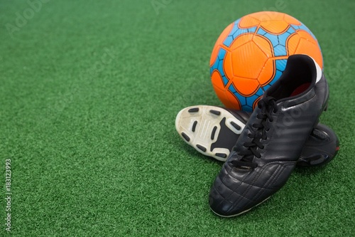 Football and cleats on artificial grass © WavebreakMediaMicro