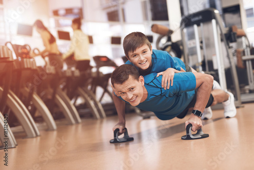 Dad and son in the same clothes in gym. Father and son lead a healthy lifestyle. © VadimGuzhva