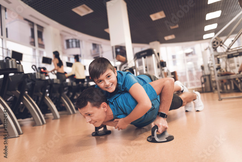 Dad and son in the same clothes in gym. Father and son lead a healthy lifestyle.