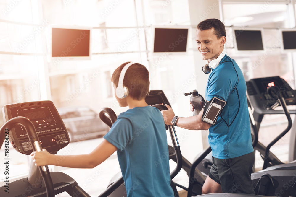 Dad and son in the same clothes in gym. Father and son lead a healthy lifestyle. Dad and son in the same clothes in gym. Father and son lead a healthy lifestyle.