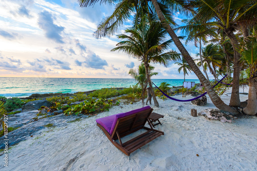 Fototapeta Naklejka Na Ścianę i Meble -  Sunset at paradise beach - Chairs under the palm trees on beach at tropical Resort. Riviera Maya - Caribbean coast at Tulum in Quintana Roo, Mexico